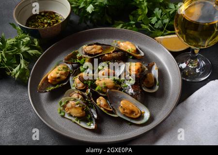 Klassische französische Mahlzeit Moules marinière Marinara Muscheln mit Knoblauch, Sauce, Zitrone und Petersilie. Stockfoto