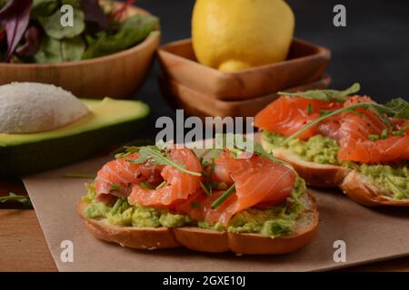 Vollkornbrot mit Avocado-Paste und Lachs, Rucola-Blätter. Stockfoto