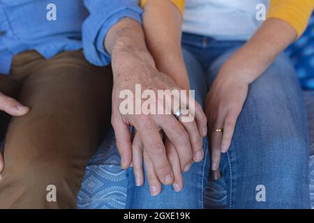 Nahaufnahme eines kaukasischen reifen Paares, das Hände mit Eheringen hält Stockfoto