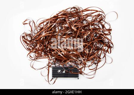 Retro-Audiokassette mit ausgezogenem Klebeband auf weißem Hintergrund Stockfoto