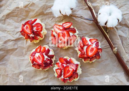 Sehr lecker Muffins mit frischen Erdbeeren liegen auf Kraftpapier. Stockfoto