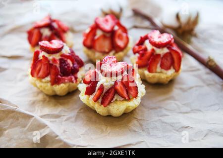 Sehr lecker Muffins mit frischen Erdbeeren liegen auf Kraftpapier. Stockfoto