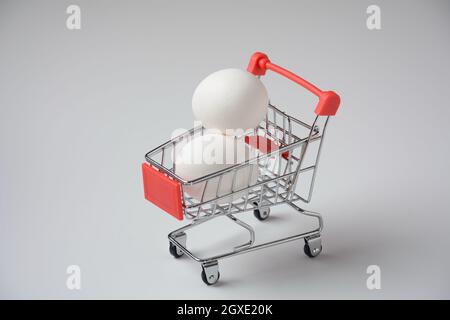 Nahaufnahme des Supermarkts Supermarkt Push-Cart für den Einkauf mit Eiern auf weißem Hintergrund. Konzept des Einkaufens. Platz für Werbung kopieren. Stockfoto