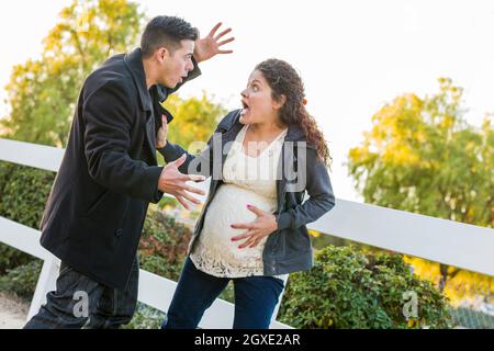 Betäubt und aufgeregt schwanger Frau und Mann mit der Hand auf Bauch draußen. Stockfoto