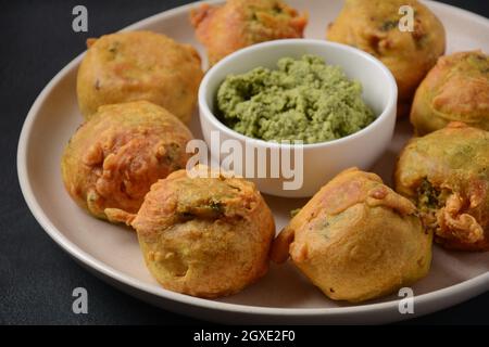 Batata vada beliebtes Straßenessen Indiens, serviert mit grünem Chutney. Stockfoto