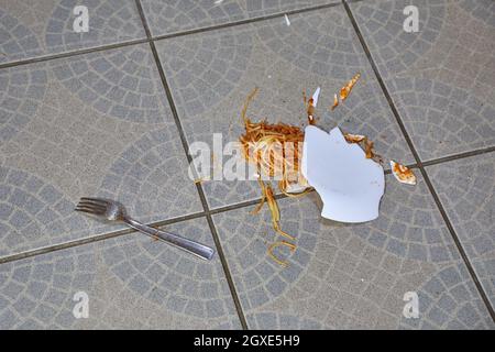 Der Teller mit Spaghetti fiel auf den Küchenboden und brach Stockfoto