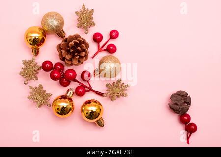 Goldene und rote Weihnachtsschmuck auf rosa Hintergrund Stockfoto