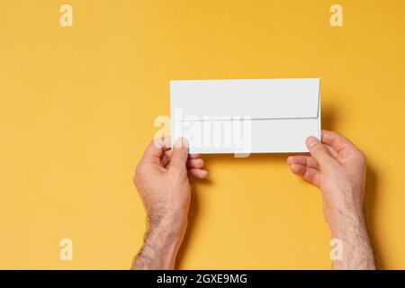 Männliche Hand mit Briefkopfpapier-Umschlag, bearbeitbare PSD-Mustervorlage mit intelligenten Objektebenen für Ihr Design, Auswahlpfad enthalten. Stockfoto