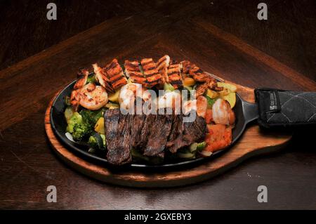 Authentische und traditionelle mexikanische Küche, bekannt als Steak Chicken Shrimps Fajitas Stockfoto