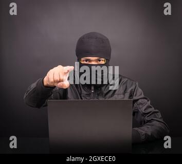 Laptop Computer Hacker Point Hand - männliche Dieb stehlen Daten Vom Laptop auf schwarzem Hintergrund Stockfoto