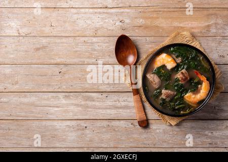 Rindfleisch, Okra-Eintopf und Spinatsuppe in einer Schüssel auf einem Holztisch Stockfoto