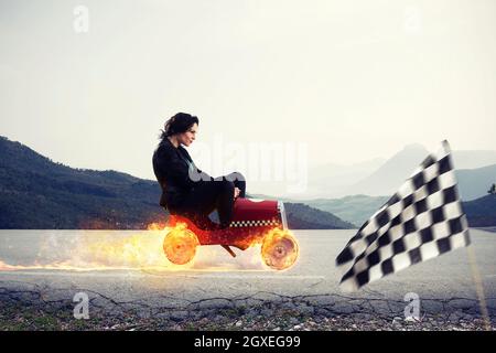 Schnelle Geschäftsfrau mit einem Auto gewinnt gegen die Konkurrenten. Konzept für geschäftlichen Erfolg und Wettbewerb Stockfoto