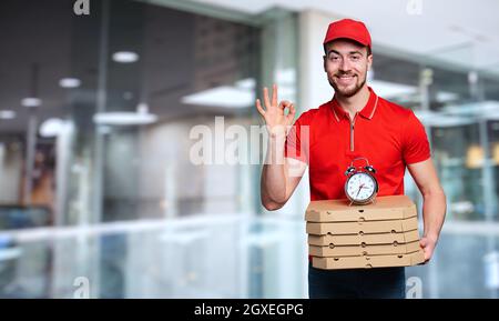 Courier ist pünktlich, um Pizzen schnell zu liefern Stockfoto