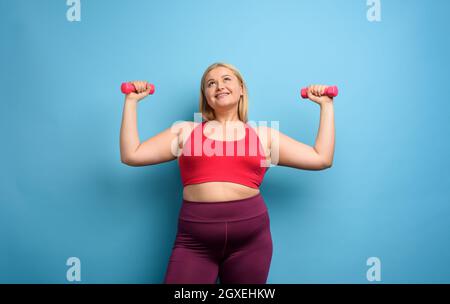 Fat Mädchen tut Fitness-Studio zu Hause. Zufrieden Ausdruck. Stockfoto