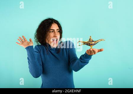 Die Frau ist glücklich, weil sie eine Lampe von aladdin gründet Stockfoto