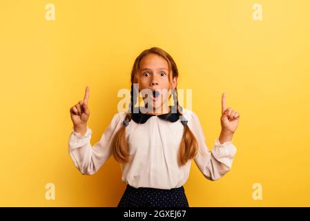 Junge Studentin ist schockiert und deutet etwas an Stockfoto