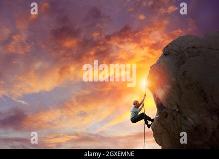 Geschäftsmann steigt auf einen Berg, um die Flagge zu erhalten. Erreichung des Geschäftsziels und schwieriges Karrierekonzept Stockfoto