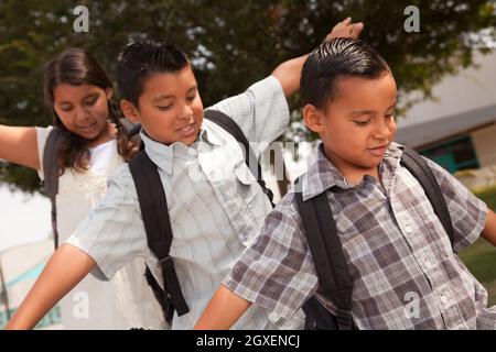 Niedliche Brüder und Schwester mit Rucksäcken Spaß zu Fuß zur Schule. Stockfoto