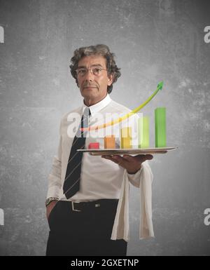 Geschäftsmann hält ein Tablett mit positiven Statistiken Stockfoto