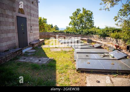 Podostrog, Budva - 23. September 2021: Kirche des heiligen Johannes des Theologen und Friedhof in der Nähe, Podostrog, Budva, Montenegro Stockfoto