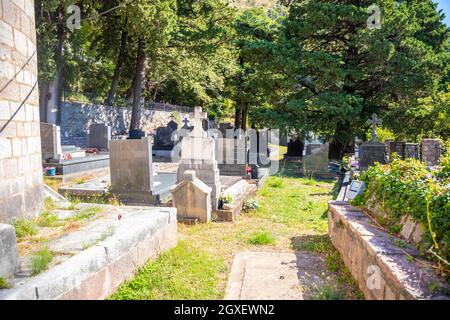 Podostrog, Budva - 23. September 2021: Kirche des heiligen Johannes des Theologen und Friedhof in der Nähe, Podostrog, Budva, Montenegro Stockfoto