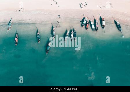 Antenne, drone Blick auf einen wunderschönen tropischen Strand mit weissem Sand, türkisklares Wasser und Longtail Boote in der Nähe von Krabi, Thailand. Stockfoto