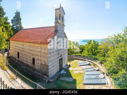 Podostrog, Budva - 23. September 2021: Kirche des heiligen Johannes des Theologen und Friedhof in der Nähe, Podostrog, Budva, Montenegro Stockfoto