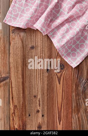 Rosafarbenes Tischtuch in Form eines Herdes auf einem Holztisch Stockfoto