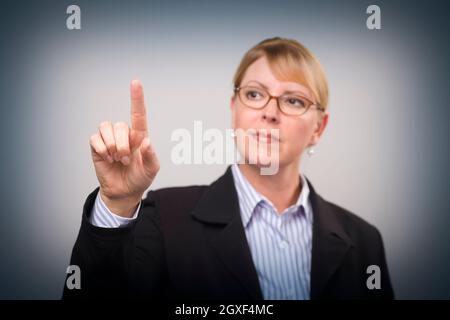 Geschäftsfrau, die sich mit dem Finger ausstreut – bereit für die eigenen Tasten oder den Touchscreen – der Fokus liegt auf ihrem Finger. Stockfoto