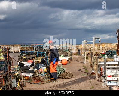 ST. ANDREWS FIFE SCHOTTLAND FISCHER UND SEINE AUSRÜSTUNG AN DER HAFENMAUER Stockfoto