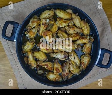 Knoblauch-Hühnerflügel (Pollo al ajillo). Spanisches Tapas-Gericht in einer Pfanne auf einer Serviette. Draufsicht Stockfoto