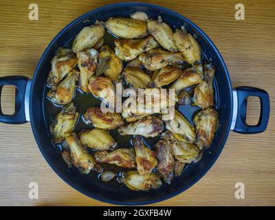 Knoblauch-Hühnerflügel (Pollo al ajillo). Spanisches Tapas-Gericht in der Pfanne. Draufsicht Stockfoto
