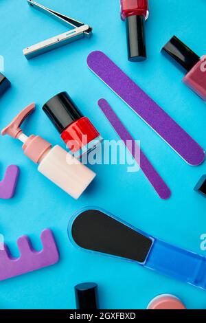 Nagelpflegeprodukte, Farblack in Flaschen auf blauem Hintergrund, niemand. Konzept der Gesundheitsverfahren, Mode Kosmetik, Maniküre und Pediküre Werkzeuge Stockfoto