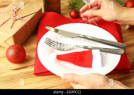 Mädchen macht Neujahrstisch Einstellung auf Holztisch. Stockfoto