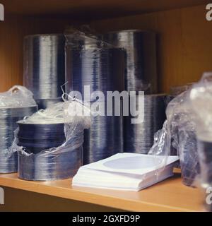 Ein Stapel von CD- und DVD-Discs in einer Verpackung im Regal Stockfoto
