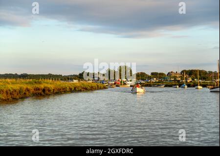 Junge Familie in einem kleinen, offenen Freizeitboot, das in der Abendsonne in Norfolk, England, vom Morston Quay aus fährt. Stockfoto