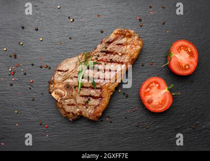 Gebratenes New Yorker Rindersteak auf einem schwarzen Brett, striploin donness selten, Draufsicht Stockfoto