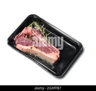 Rohes New Yorker Rindersteak wird in einem Kunststoffbehälter verpackt und vakuumversiegelt. Langfristige Lagerung von Striploin-Fleisch Stockfoto