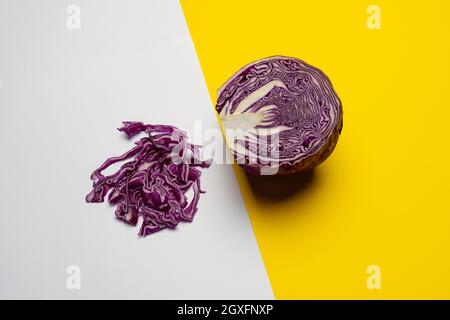 Ein Rotkohl in zwei Hälften geschnitten und auf ein gelegt Farbige Oberfläche Stockfoto