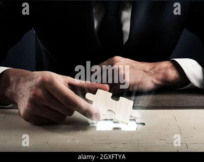 Geschäftsmann vervollständigen ein Puzzle einfügen letztes Stück Stockfoto