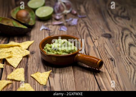 Avocado Dip mit Knoblauch, Chili, Pfeffer und Limettensaft mit Mais Nachos gewürzt Stockfoto