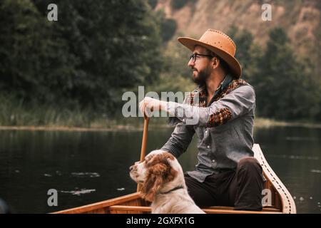 Mann und Hund im Kanu auf dem Fluss Stockfoto