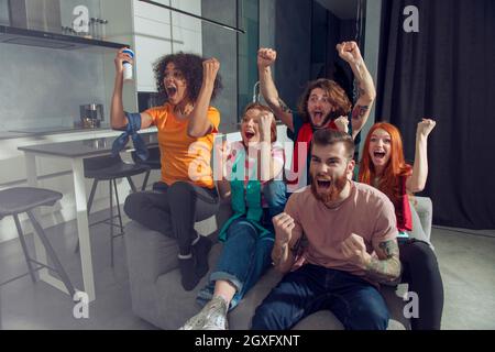 Gerne Freunde von Fußball-Fans Fußball gerade auf tv und feiern den Sieg. Freundschaft, Sport und Unterhaltung Konzept. Stockfoto