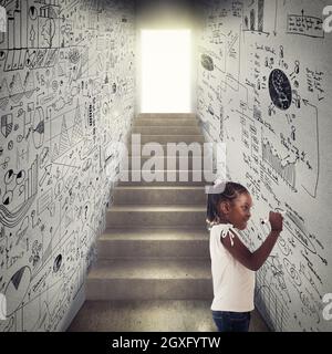 Das kleine Mädchen greift auf die Analyse des Wandgeschäfts zurück Stockfoto