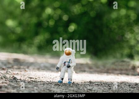 Spielzeug-Astronaut auf dem Boden stehend. Spaceman Figur Reisekonzept Umweltschutz. Astronaut erforscht den neuen Planeten. Auf der Suche nach einem neuen Zuhause für Stockfoto