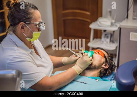 Mann, der Zähne bei Zahnärzten untersucht hat. Zahnärztliche Behandlung in der Zahnmedizin. Termin beim Zahnarzt. Lifestyle, echtes Leben Stockfoto