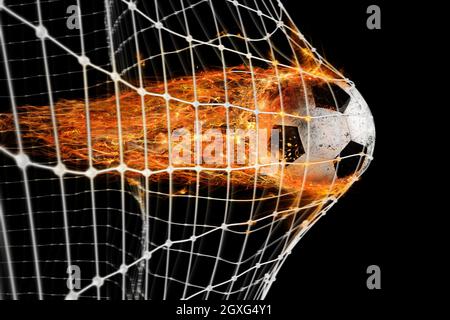Der professionelle Fußball-Feuerball hinterlässt Spuren von Flammen und erzielt ein Tor im Netz Stockfoto