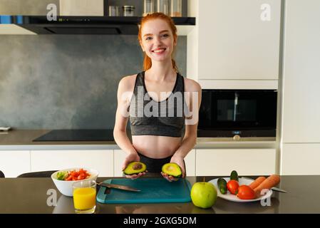 Athletische Frau mit Turnkleidung isst Früchte Stockfoto