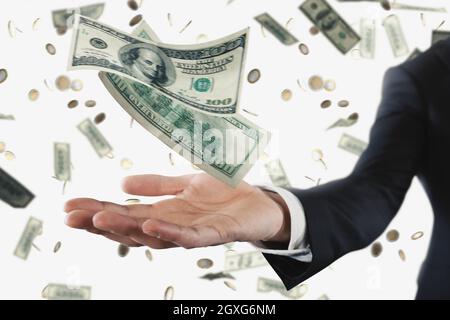 Geschäftsmann mit verregneten Dollar-Banknoten isoliert auf weißem Hintergrund. Konzept von Erfolg, Karriere und großem Einkommen Stockfoto