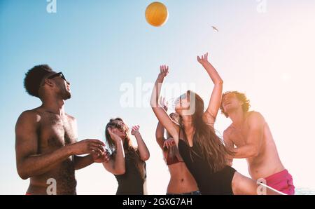 Eine Gruppe von Freunden, die gerne am Beachvolleyball am Strand Stockfoto